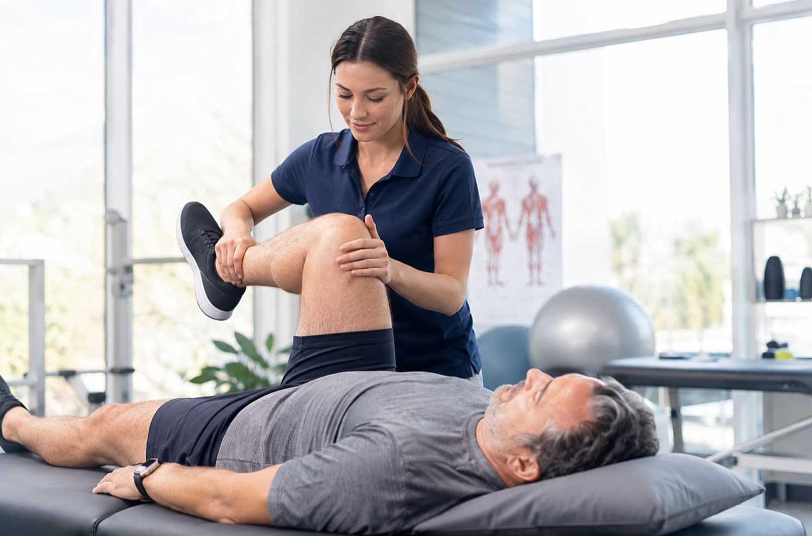 A physiotherapist treats a patient’s knee