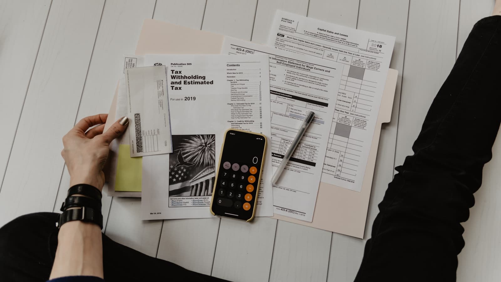 Calculadora, documentos y un teléfono sobre la mesa de una pequeña oficina